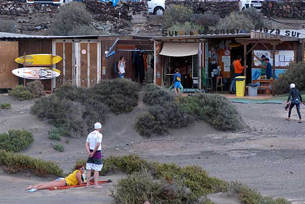 In Holzhütten haben die Surfschulen ihre Surfbretter gelagert. Teneriffa - Playa del Médano - Surferbasis am Strand